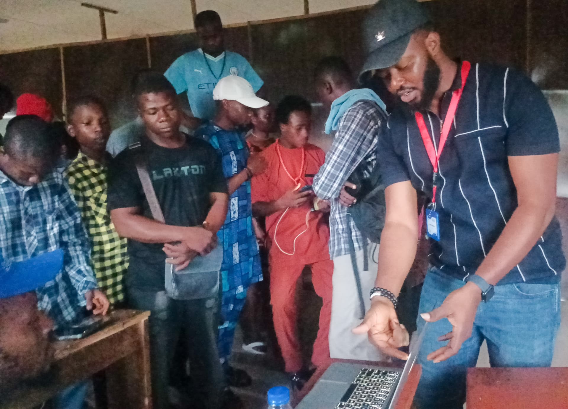 Participants gathered around a laptop during a FACE 2025 training session